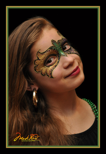 girl with a green and gold mask painted around her eyes
